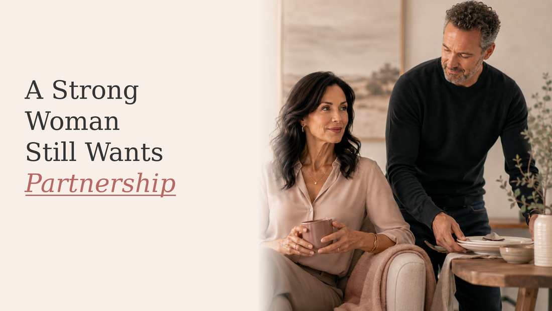 Strong midlife woman relaxing on a sofa with a supportive partner close beside her in a warm neutral home.