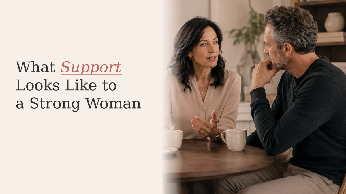 Strong midlife woman seated with a mug while her partner listens beside her in a calm home setting.
