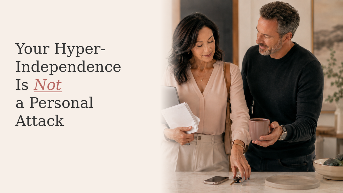 Self-possessed midlife woman holding a tablet and papers while her partner offers quiet practical support at home.