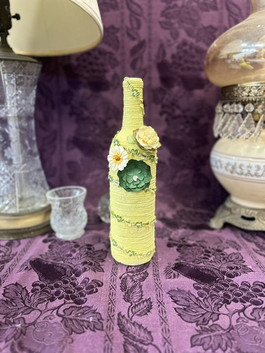 Decorative Wine Bottle Wrapped in yellow string accented with green flowers Decorative Bottles Stylin’ Spirit   